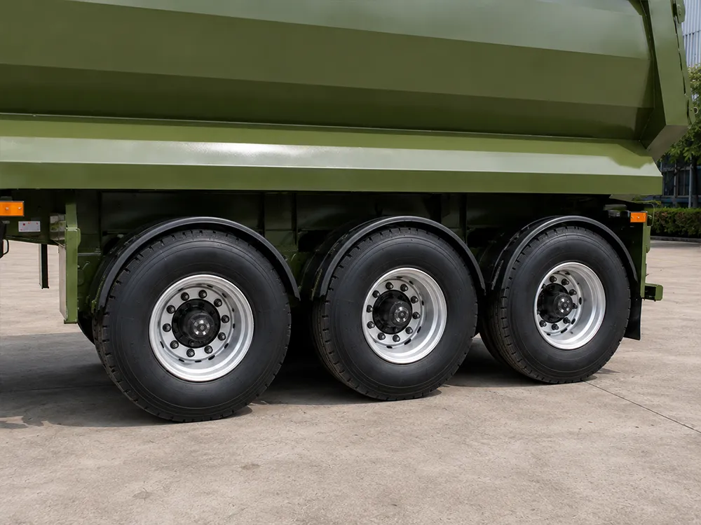 Semi-remorque à benne basculante arrière de type U, 3 essieux, couleur vert militaire – Gros plan sur un pneu à trois essieux